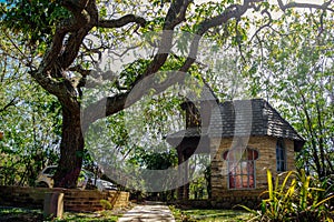 Chapel of prayers, next to large trees, in a public park.