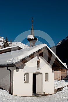 Chapel under the snow in the mountains