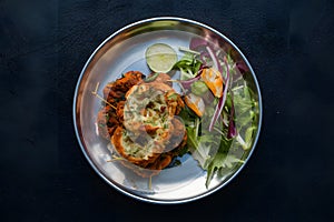 Chapli kabab served with fresh salad, a classic Indian dish