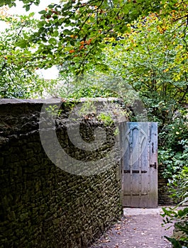 Characterful blue gate at entrance to terrace garden at Dyrham Park National Trust property, Gloucestershire, UK