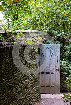 Characterful blue gate at entrance to terrace garden at Dyrham Park National Trust property, Gloucestershire, UK