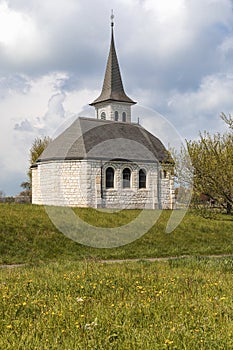 Characteristic church in the green field in the Swiss Alps of the Canton Jura