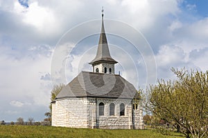 Characteristic church in the green field in the Swiss Alps of the Canton Jura