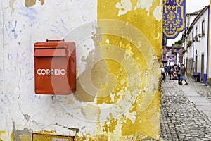 Characteristic Correio Box in english: Mail Box in a little village in Portugal. Red mail box against a white and yellow photo