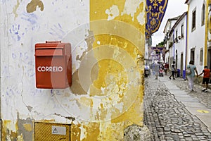 Characteristic Correio Box in english: Mail Box in a little village in Portugal. Red mail box against a white and yellow photo