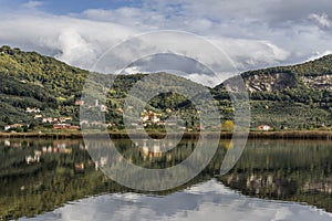 The characteristic village of Massaciuccoli is reflected in the waters of the homonymous lake, Lucca, Tuscany, Italy photo