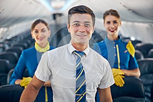 Characters steward in uniform looking at the photo camera in salon of aircraft