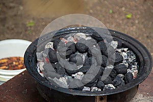 Charcoal bricks burning in a barbecue smoker at the cottage.