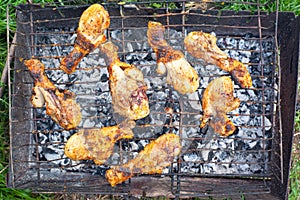 Charcoal grilled chicken legs, cooking meat on the grill