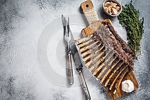 Charcoal Grilled French rack of Lamb Ribs Chops on cutting board. White background. Top view. Copy space