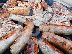 Charcoal grilled out door pork belly and homemade sausages on a barbecue grill