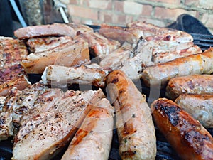 Charcoal grilled out door pork belly and homemade sausages on a barbecue grill