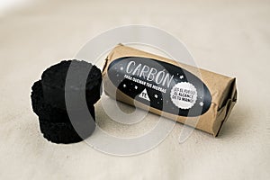 Charcoal tablets to light energy herbs next to their packaging