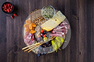 Charcuterie board arrangement of Italian meats, cheese and finger foods.