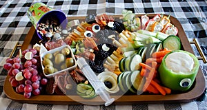 Charcuterie board created for Halloween celebration. Plate of assorted fruit, vegetable and meat appetizers on the table