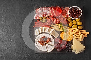 Charcuterie board with spanish jamon, pork sausage with pepper, fuet, cheese and berries. Copy space for text
