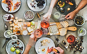 Charcuterie and cheese board, rose wine, snacks and peoples hands