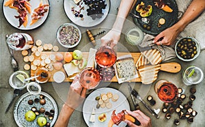Charcuterie and cheese board, rose wine, snacks and peoples hands photo