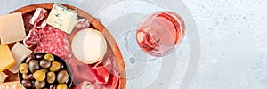 Charcuterie and cheese panoramic banner, shot from above with rose wine