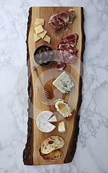 Charcuterie on a rustic cutting board on a marble surface photo