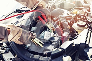 Charging dead car battery with jumper cables