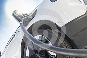 charging EV car electric vehicle clean energy for driving future. close-up shot in sunny blue sky background