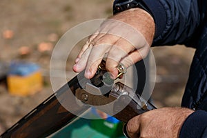 Charging a hunting rifle. Male hunter charges a double-barreled shotgun rounds