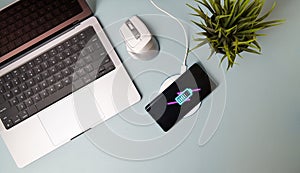 Charging mobile phone battery with wireless charging device on the table.