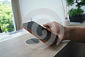 Charging mobile phone battery with wireless charging device in the table