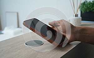 Charging mobile phone battery with wireless charging device in the table