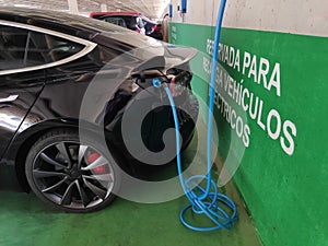 Charging a modern electric car in a public parking lot, they are the future of motorsport with their smart technology.