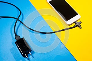 A charging phone connected with adapter block through black cable