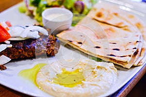 Chargrilled Minced Lamb with Hummus, Pitta Bread and Salad in White Plate