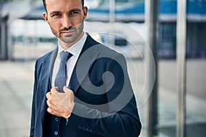 Charismatic brunette man touching his neck tie