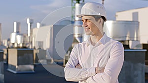 Charismatic businessman posing in front of the camera on the top of construction site he wearing safety helmet he