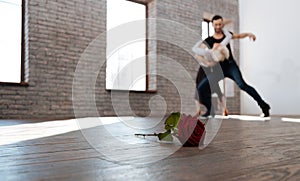 Charismatic dance teacher tangoing with senior woman at the ballroom