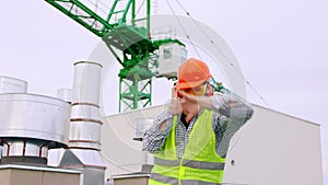 Charismatic engineer man dancing and feeling excited on top of construction site he wearing all equipment for safety in