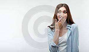 Charismatic girl is giggling and covers her mouth with her hand. Human emotions, facial expression concept