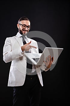 Charismatic guy in a suit with ntebook