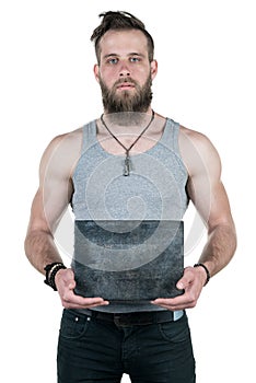 A charismatic man with a beard holds an empty gray plate for a copy space on a white isolated background. Vertical frame