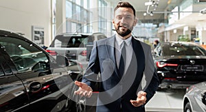 charismatic respectable car dealership owner greets new customers in the showroom with a smile on his face
