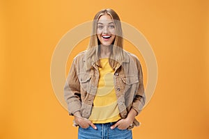 Charismatic tanned woman in corduroy jacket and yellow t-shirt ready for chilly autumn walk with friends smiling