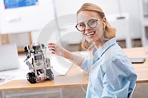 Charismatic woman enjoying music with electronic robot indoors