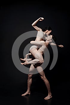 Charismatic young performers dancing in the black colored studio