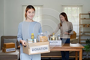 charity, donation and volunteering concept. Volunteer prepare foodstuff box containing food to donate to people poor