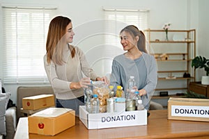 charity, donation and volunteering concept. Volunteer prepare foodstuff box containing food to donate to people poor