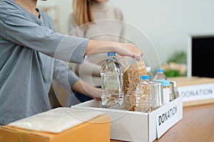 charity, donation and volunteering concept. Volunteer prepare foodstuff box containing food to donate to people poor