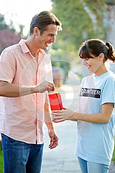 Charity Worker Collecting From Man In Street