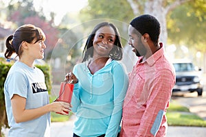 Charity Worker Collecting Sponsorship From Couple In Street