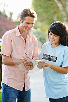 Charity Worker Collecting Sponsorship From Man In Street